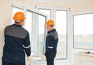 Two Green Contractors FL technicians installing an impact window