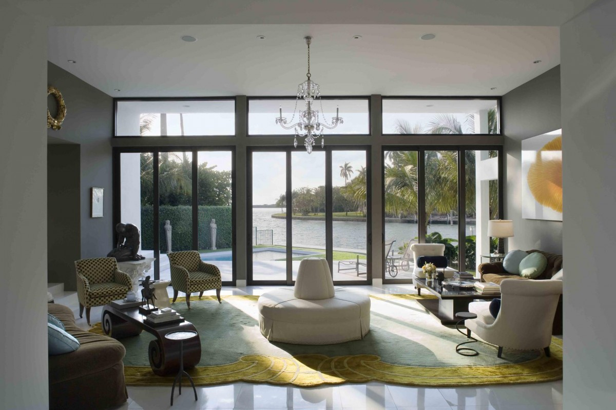 Living room with floor-to-ceiling impact windows framing a waterfront view