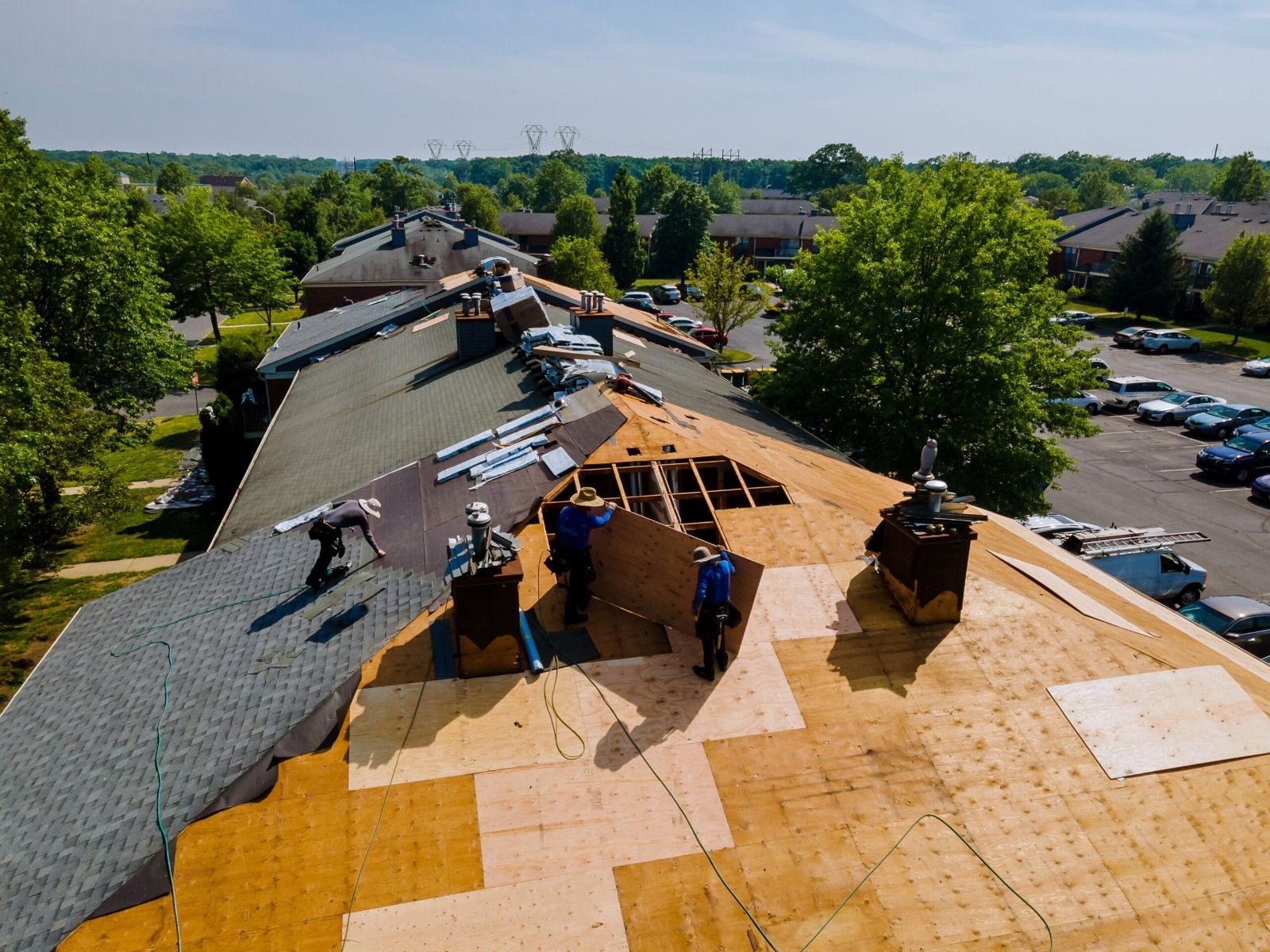 Aerial view of a residential roofing crew installing a new asphalt shingle roof