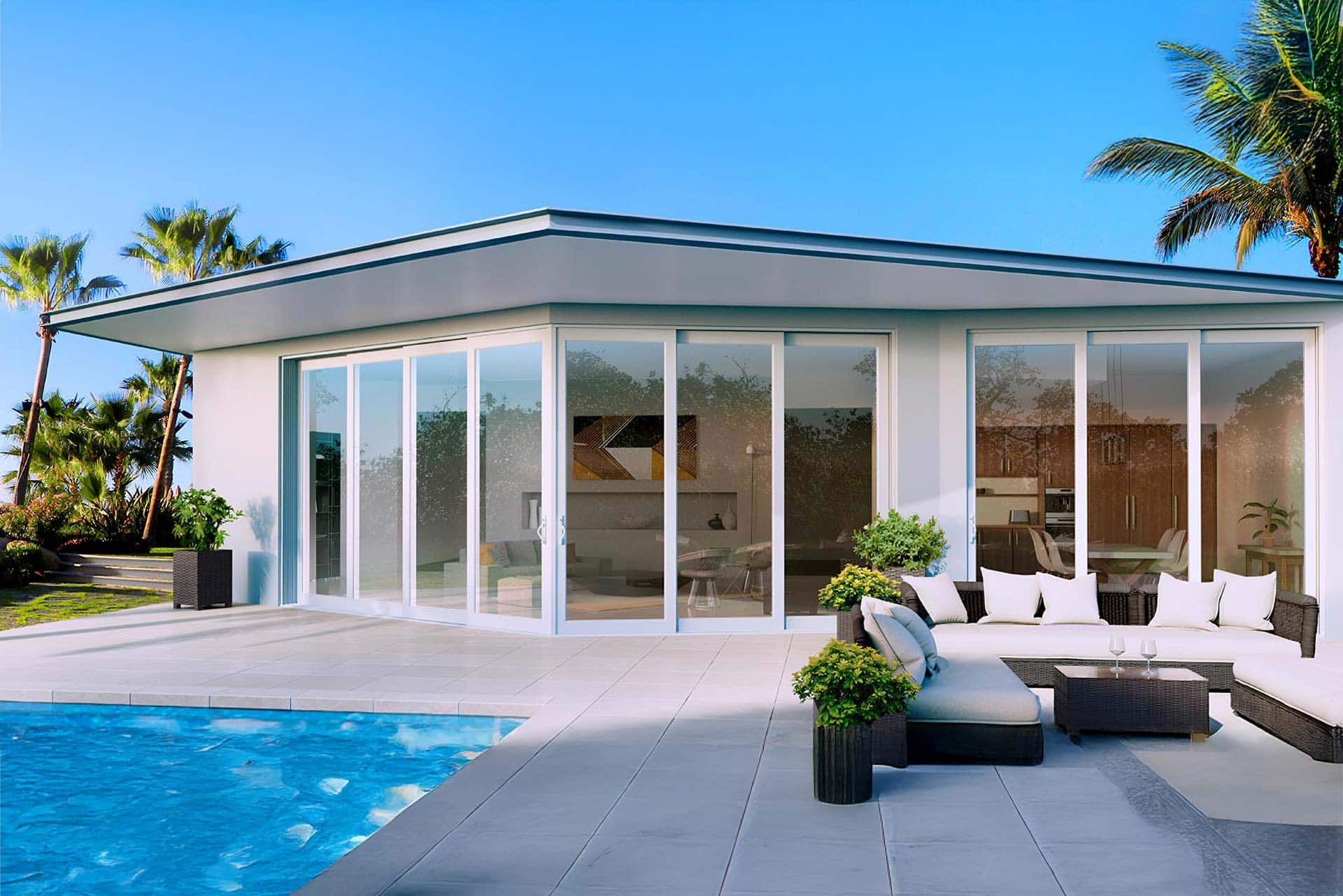 Modern poolside home with full-height impact glass walls and sliding doors