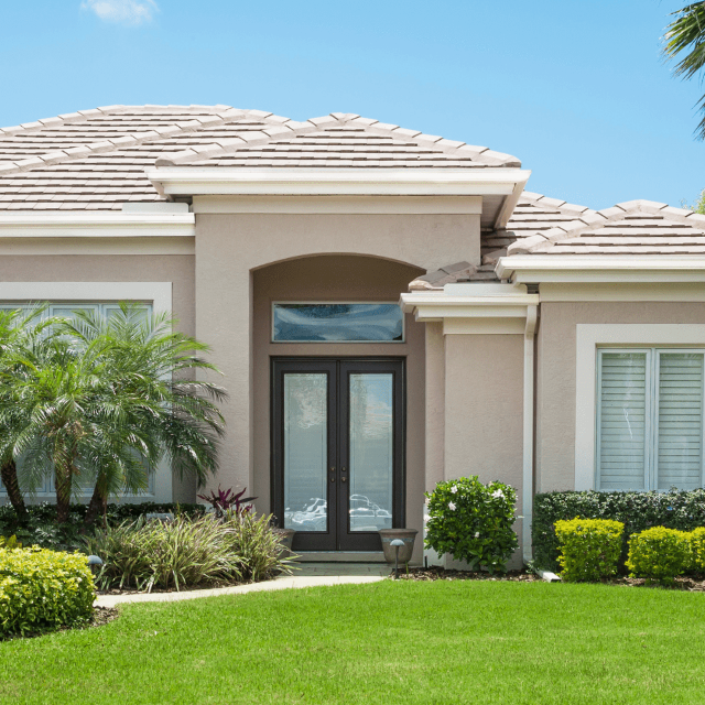 Dark impact entry doors with a transom window on a Florida stucco home