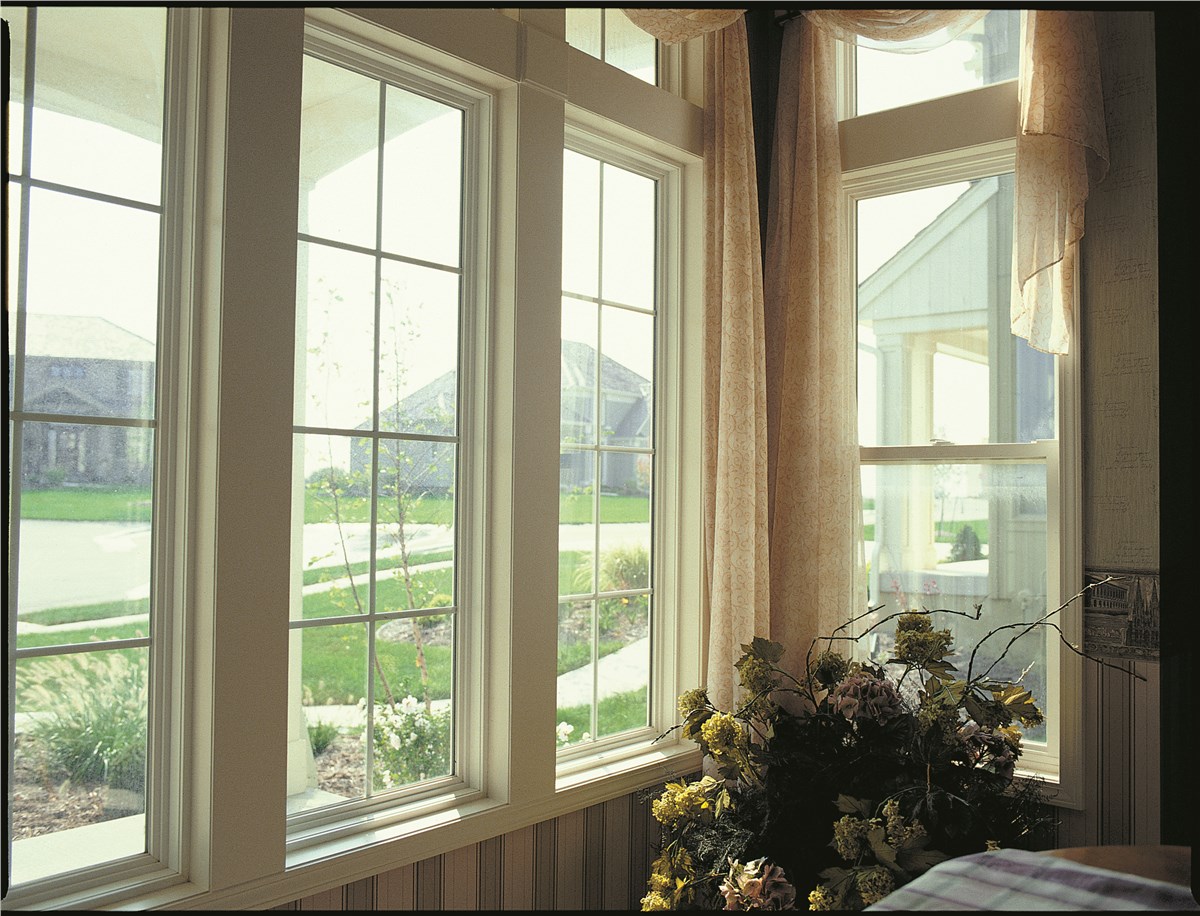 White double-hung impact windows installed in a Florida home overlooking the yard