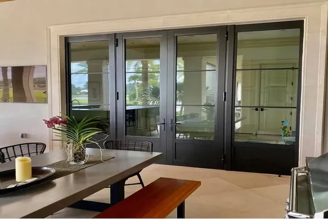 Dark-framed impact French doors seen from inside a dining room