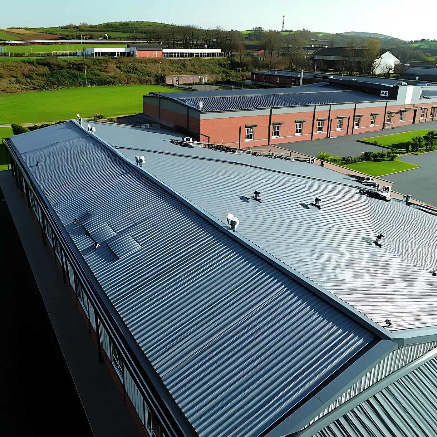 Aerial view of a large commercial metal roof on an industrial building