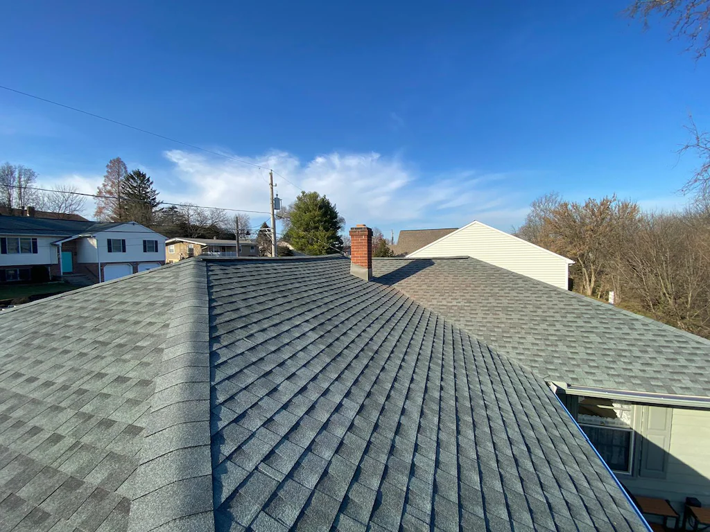 Aerial view of a residential roof replacement crew installing new shingles