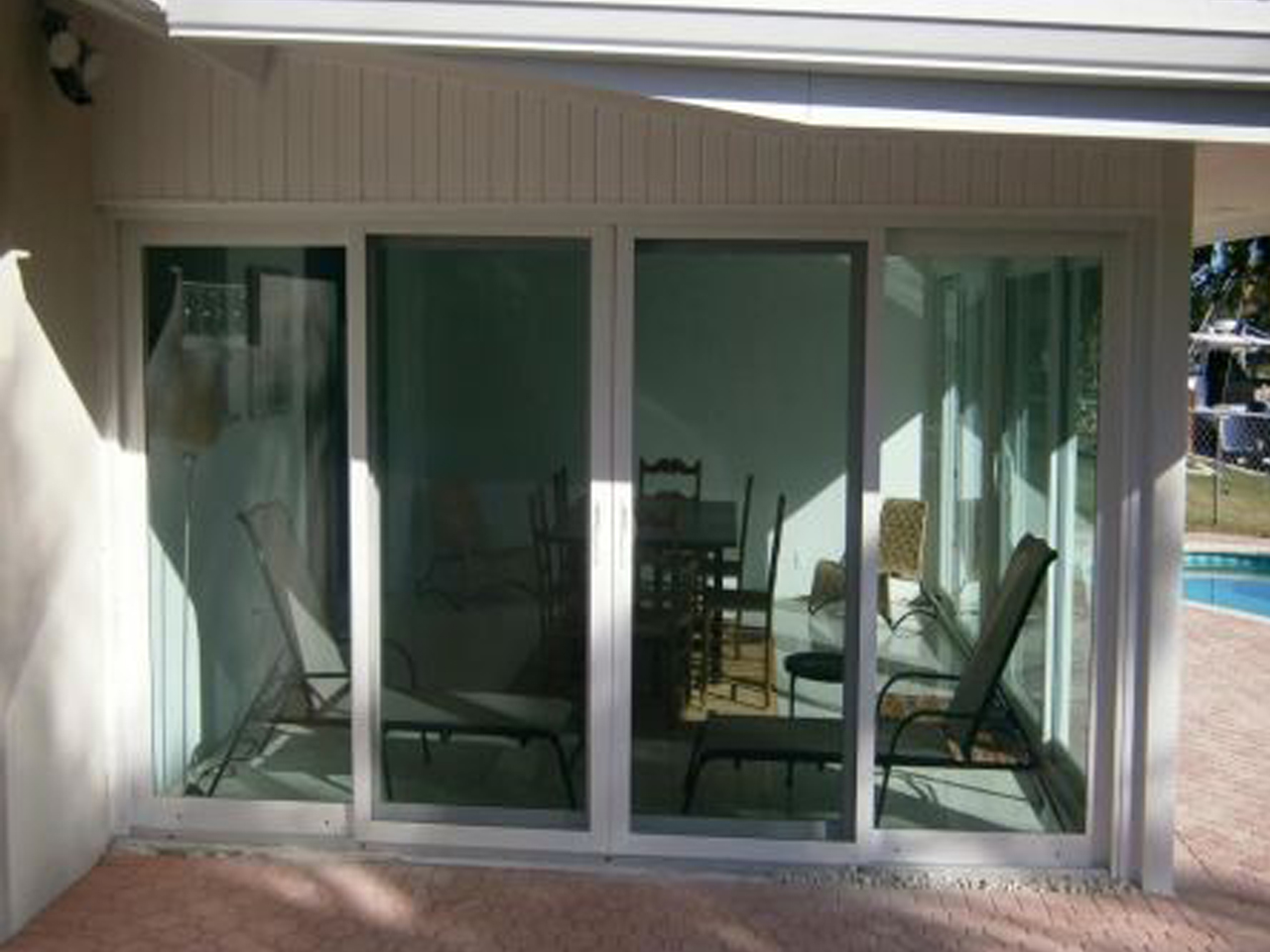 White-framed sliding glass doors on a covered patio after installation