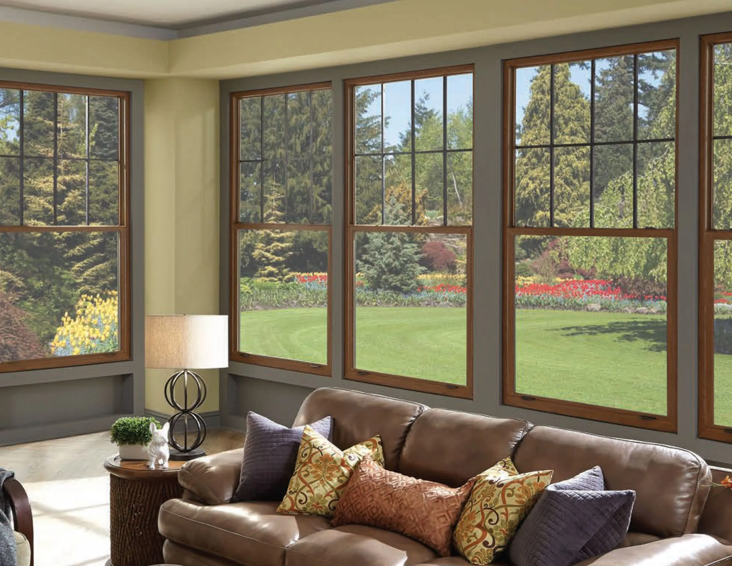 Living room with wood-framed picture windows overlooking a garden