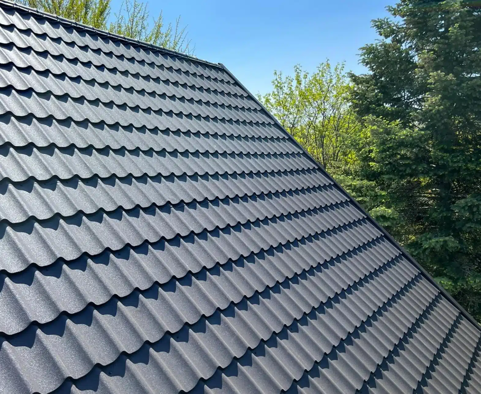 Close-up of a grey stone-coated metal tile roof