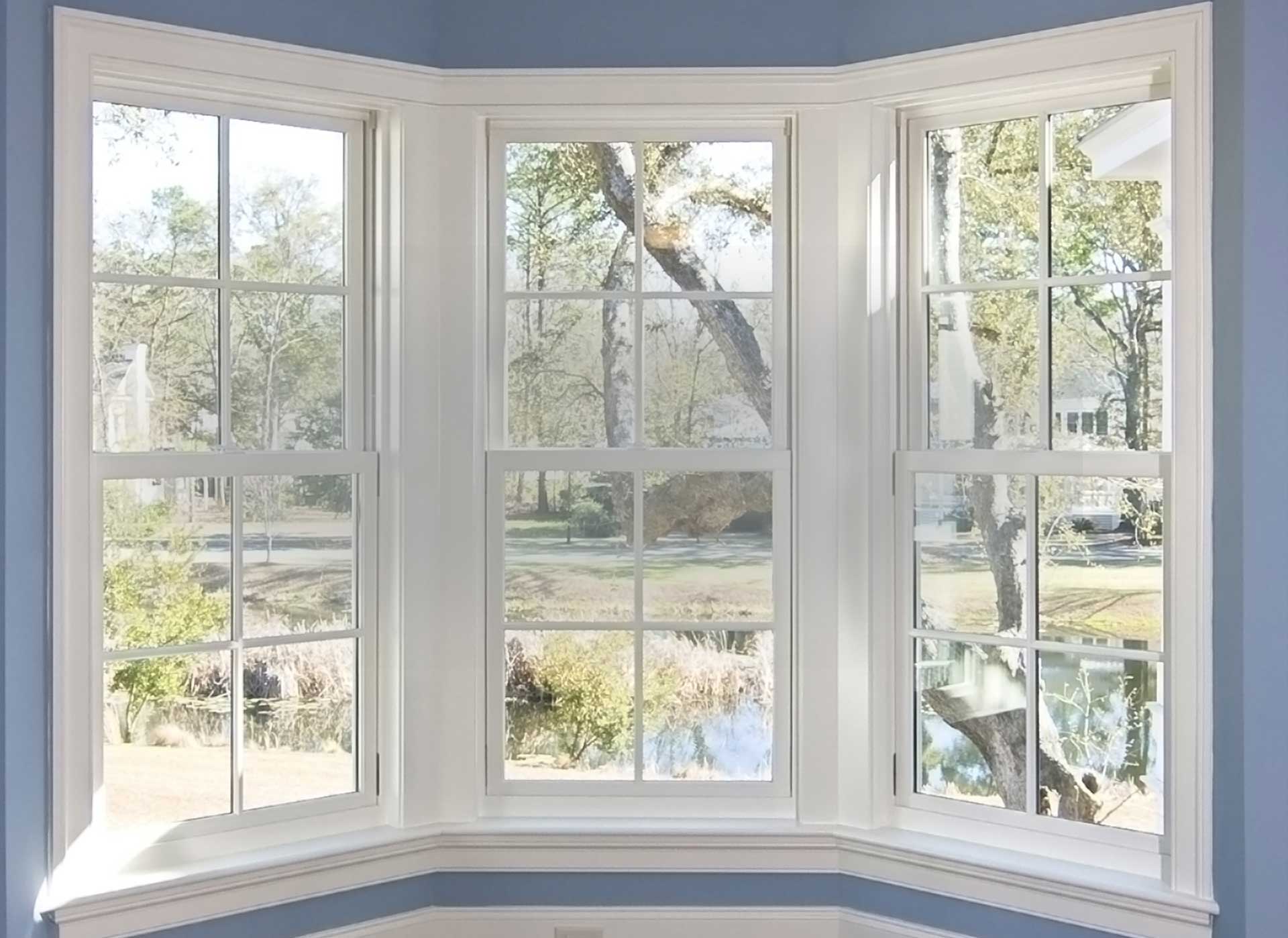 White bay window with colonial grids overlooking a yard